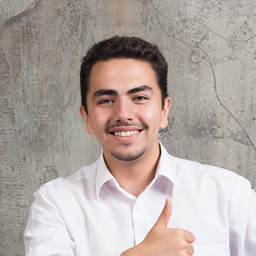 Smiling man showing thumb up and sitting at the desk. High quality photo